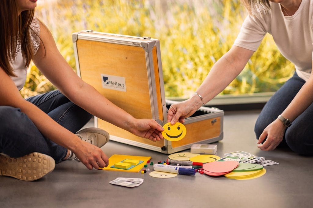 REFLECT-Workshop mit Moderationsmaterial und Smiley-Karten